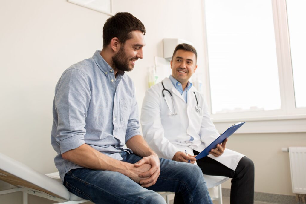 A young man meeting a doctor in an examination room for a wellness checkup, one of the important pre…