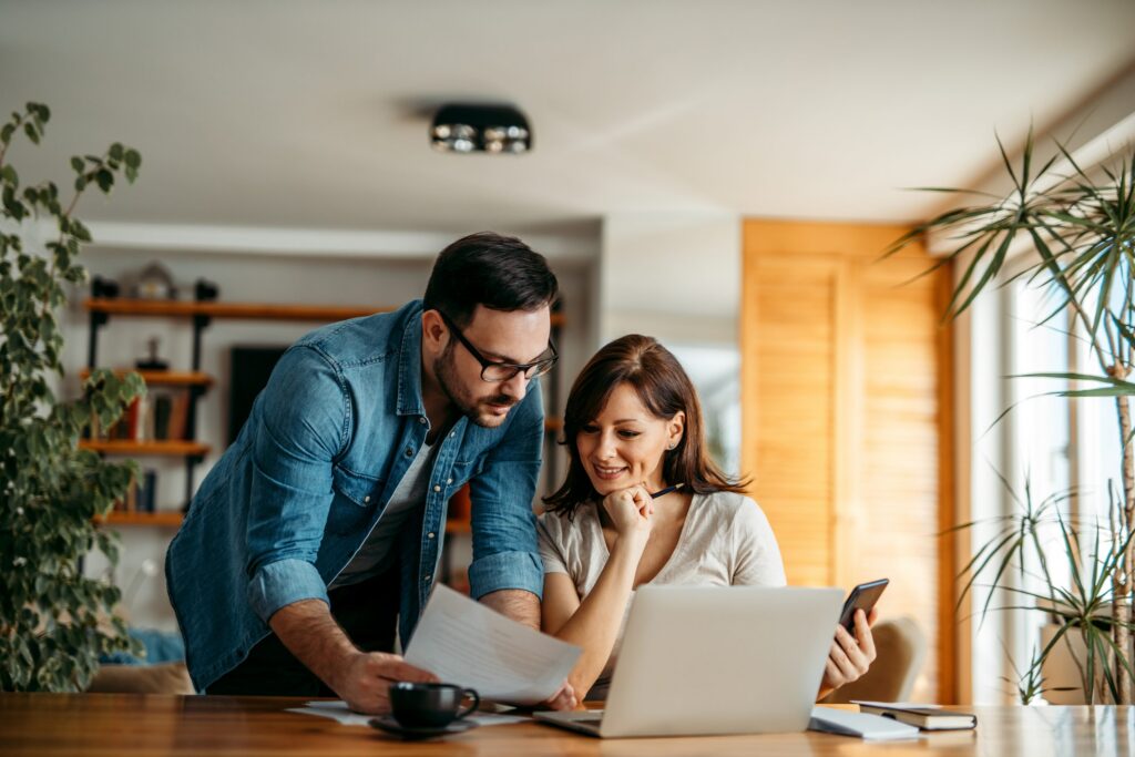 A couple at home with their laptop, considering health insurance options with Cost-Sharing Reductions.