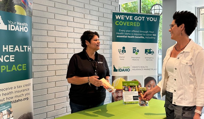 A member of the Outreach team at Your Health Idaho meeting with a consumer as part of the event schedule.