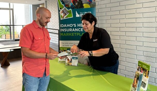A member of the Outreach team at Your Health Idaho meeting with a consumer as part of the event schedule.